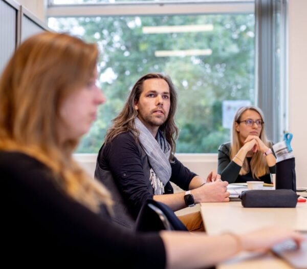 Mensen in klaslokaal luisteren aandachtig